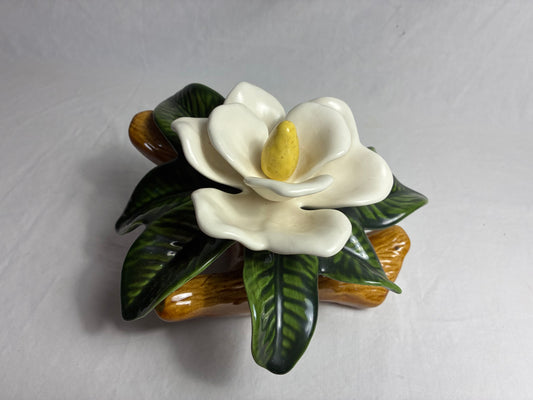 Ceramic magnolia figurine on branch